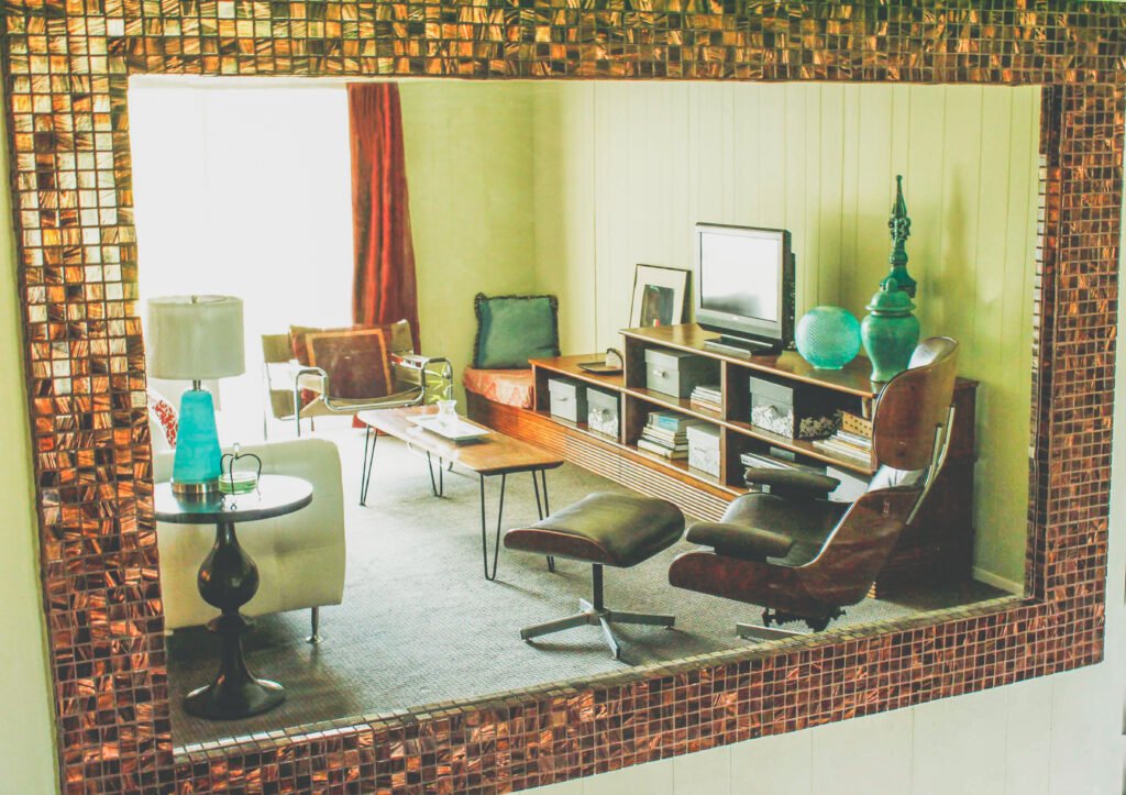 wall mirror reflects living room with custom bookcase